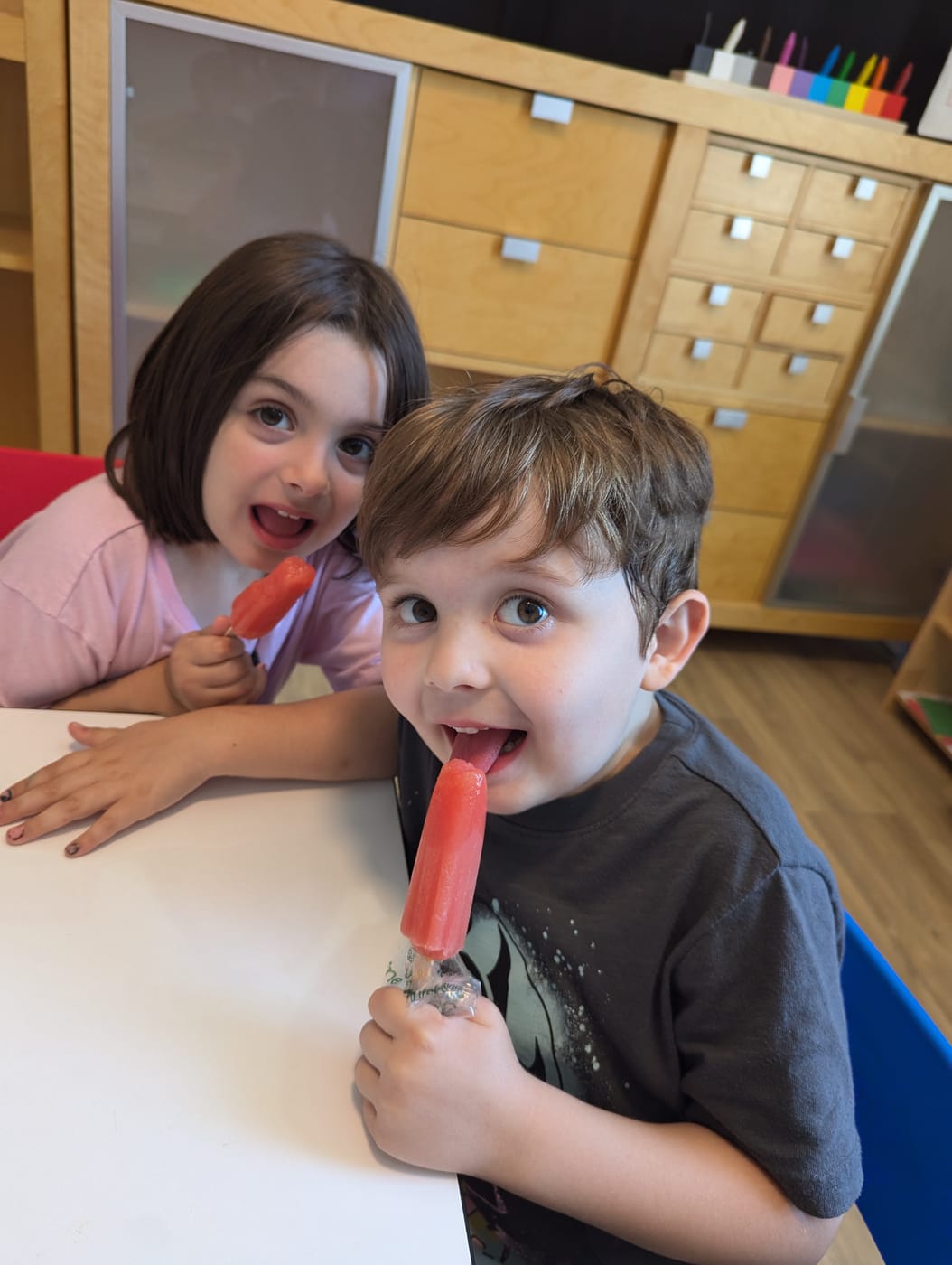 Two friends enjoying popsicles