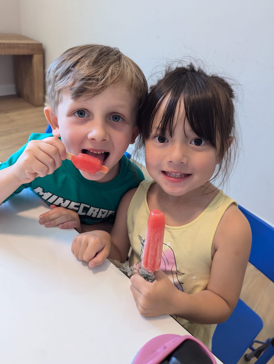 Two smiling friends with popsicles