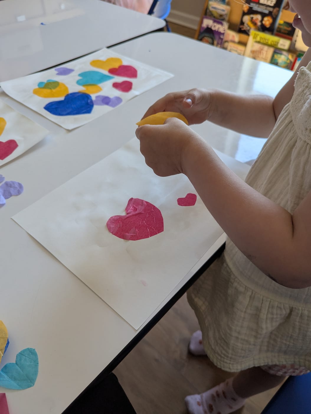 A child making a tissue-paper heart collage