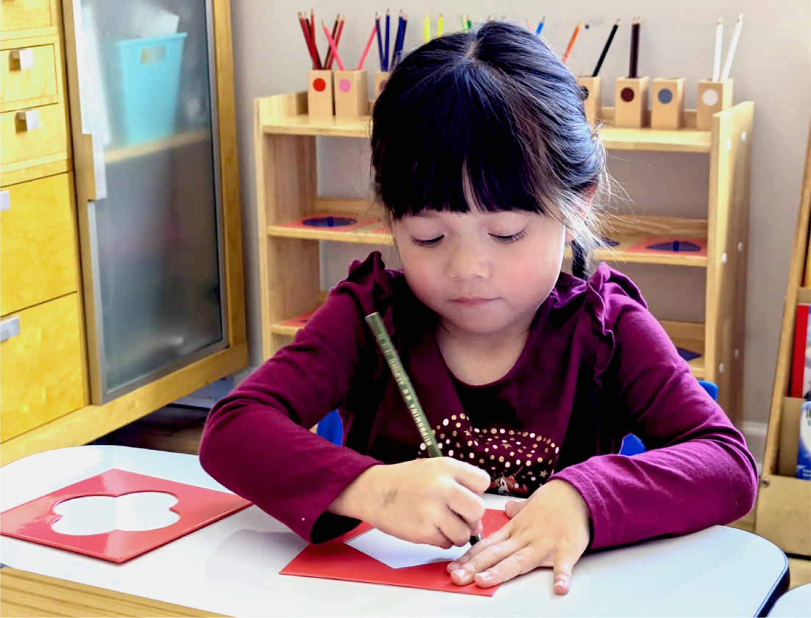 A student tracing a metal inset at the work table